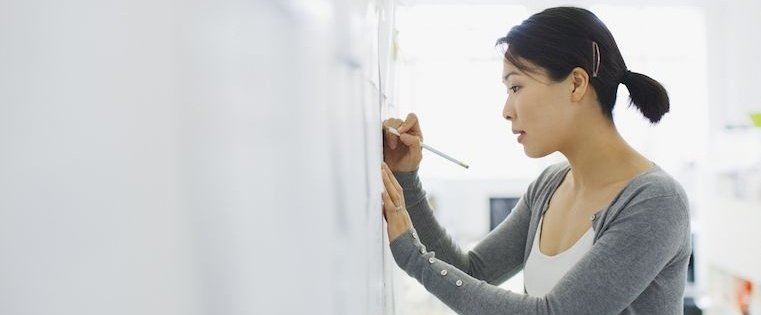 woman creating sales close plan on whiteboard